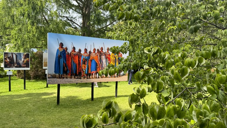 Festival Baden, © Lois Lammerhuber Outdoor-Fotoausstellung mit Bildern von Menschen in traditioneller Kleidung auf einer Wiese.