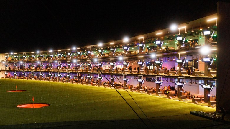 Winterlicher Abschlag mit Aussicht, © Topgolf Wien Beeindruckende Abendstimmung bei Topgolf mit beleuchteten Abschlagplätzen auf mehreren Ebenen und zahlreichen Gästen beim gemeinsamen Spielen und Genießen.