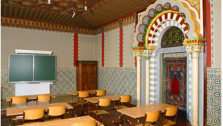 Ein klassenzimmer mit maurischem Dekor, bunten Fliesen und Holzm&ouml;beln.