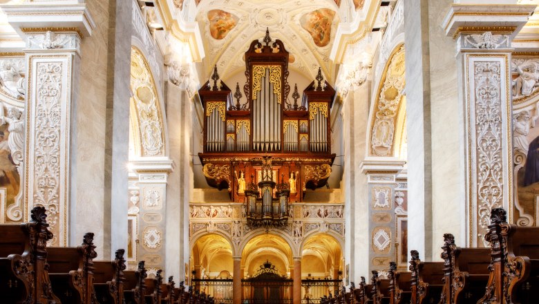 Pr&auml;chtige Orgel in einer reich verzierten Kirche mit kunstvollen Holzschnitzereien und Fresken.